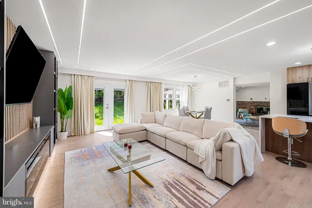 a living room with furniture a flat screen tv and a large window