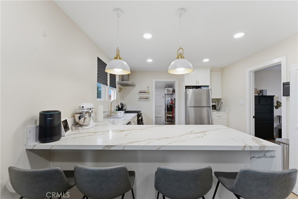 14335 Leffingwell Road Whittier, CA 90604 - Photo 13 of 42 a kitchen with a table chairs refrigerator and microwave