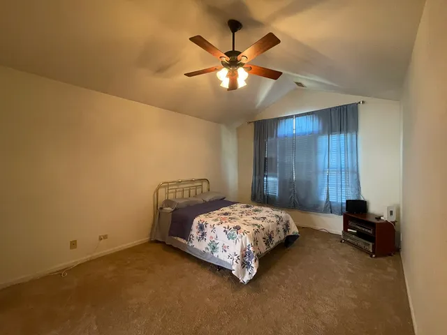 a bedroom with a bed and a ceiling fan