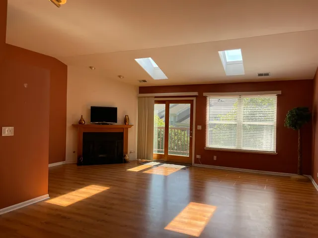 a view of room with wooden floor and windows