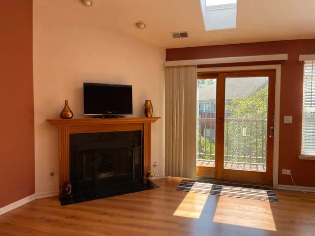 a living room with a fireplace and a floor to ceiling window