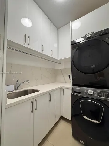 a utility room with sink dryer and washer