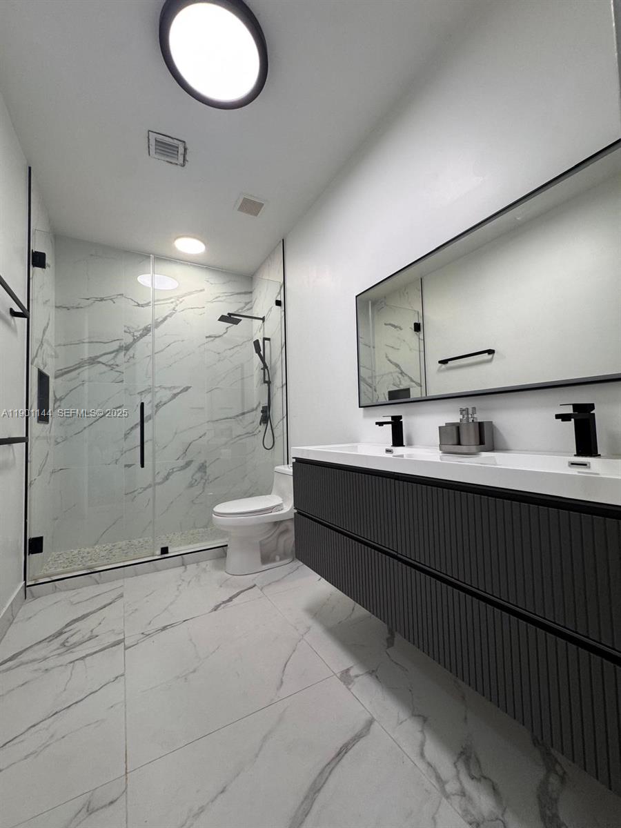 8850 Northwest 98th Court Doral, FL 33178 - Photo 15 of 26 a bathroom with a double vanity sink toilet and shower