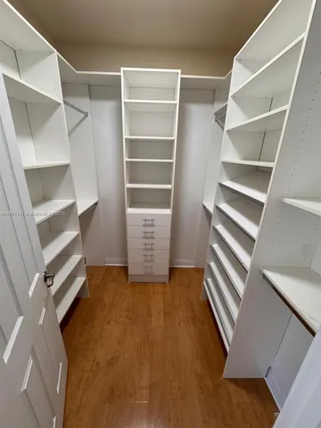 a view of walk in closet with empty racks
