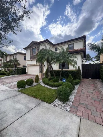a front view of a house with a yard and potted plants