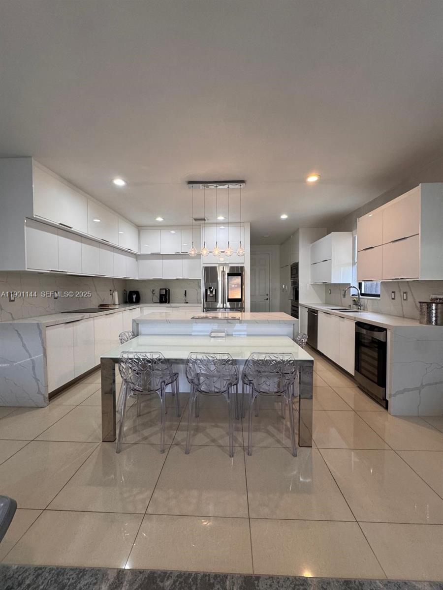 8850 Northwest 98th Court Doral, FL 33178 - Photo 3 of 26 a large kitchen with stainless steel appliances granite countertop a sink and cabinets