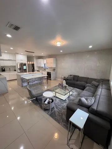 a living room with furniture and kitchen view