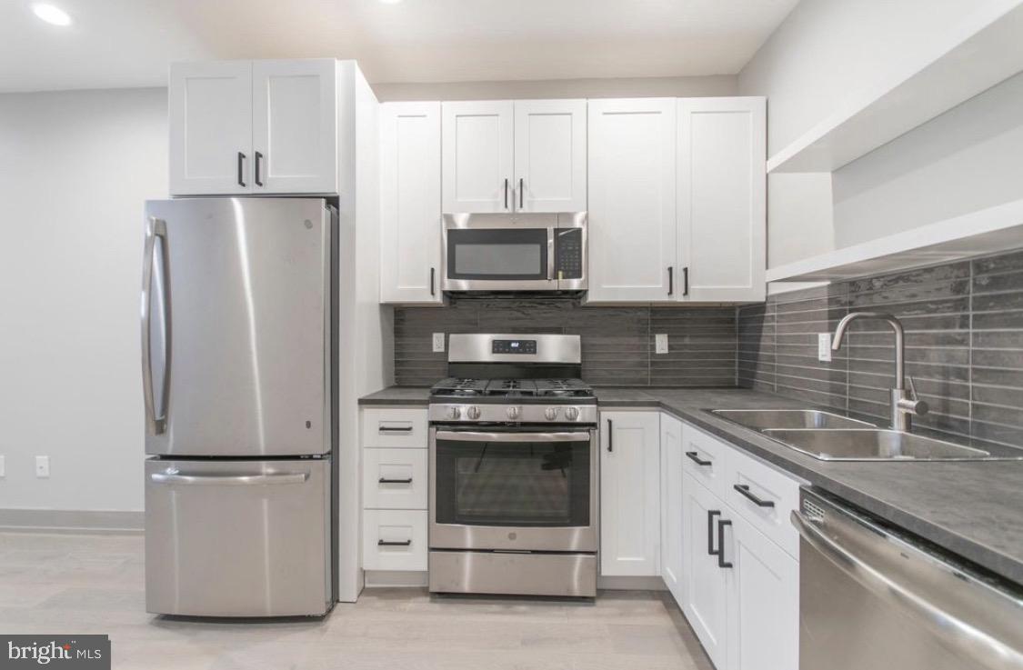 3339 Ridge Avenue Philadelphia, PA 19132 - Photo 17 of 33 a kitchen with granite countertop a stove and a refrigerator