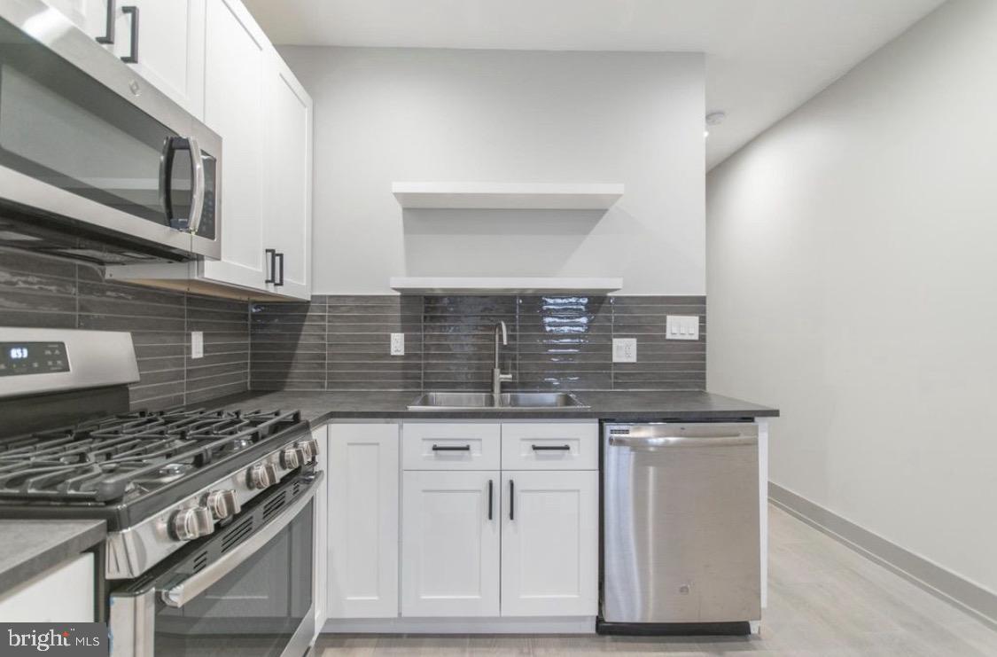 3339 Ridge Avenue Philadelphia, PA 19132 - Photo 20 of 33 a kitchen with granite countertop a stove sink and cabinets