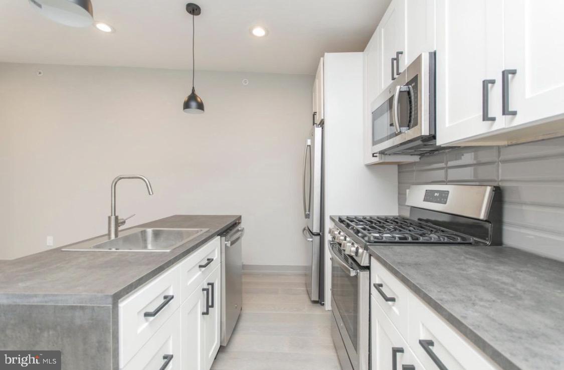 3339 Ridge Avenue Philadelphia, PA 19132 - Photo 3 of 33 a kitchen with stainless steel appliances granite countertop a sink stove and cabinets