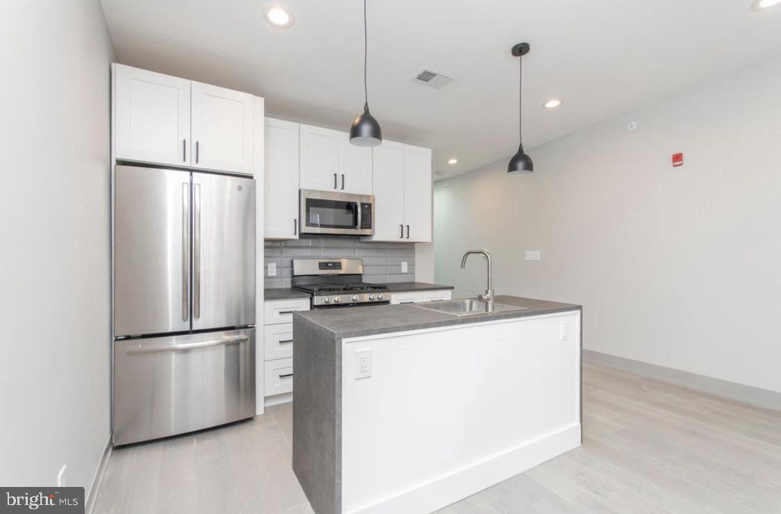 3339 Ridge Avenue Philadelphia, PA 19132 - Photo 6 of 33 a kitchen with stainless steel appliances a refrigerator stove and microwave