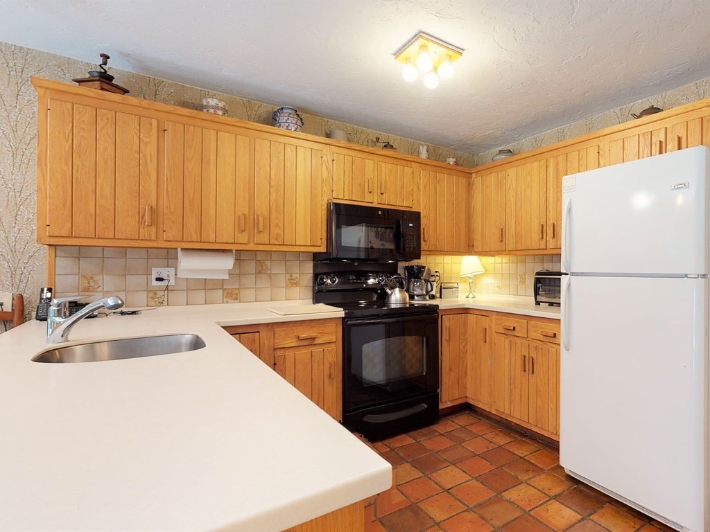 19 Lambert Road Belmont, MA 02478 - Photo 16 of 42 a kitchen with granite countertop a refrigerator stove top oven a sink and dishwasher