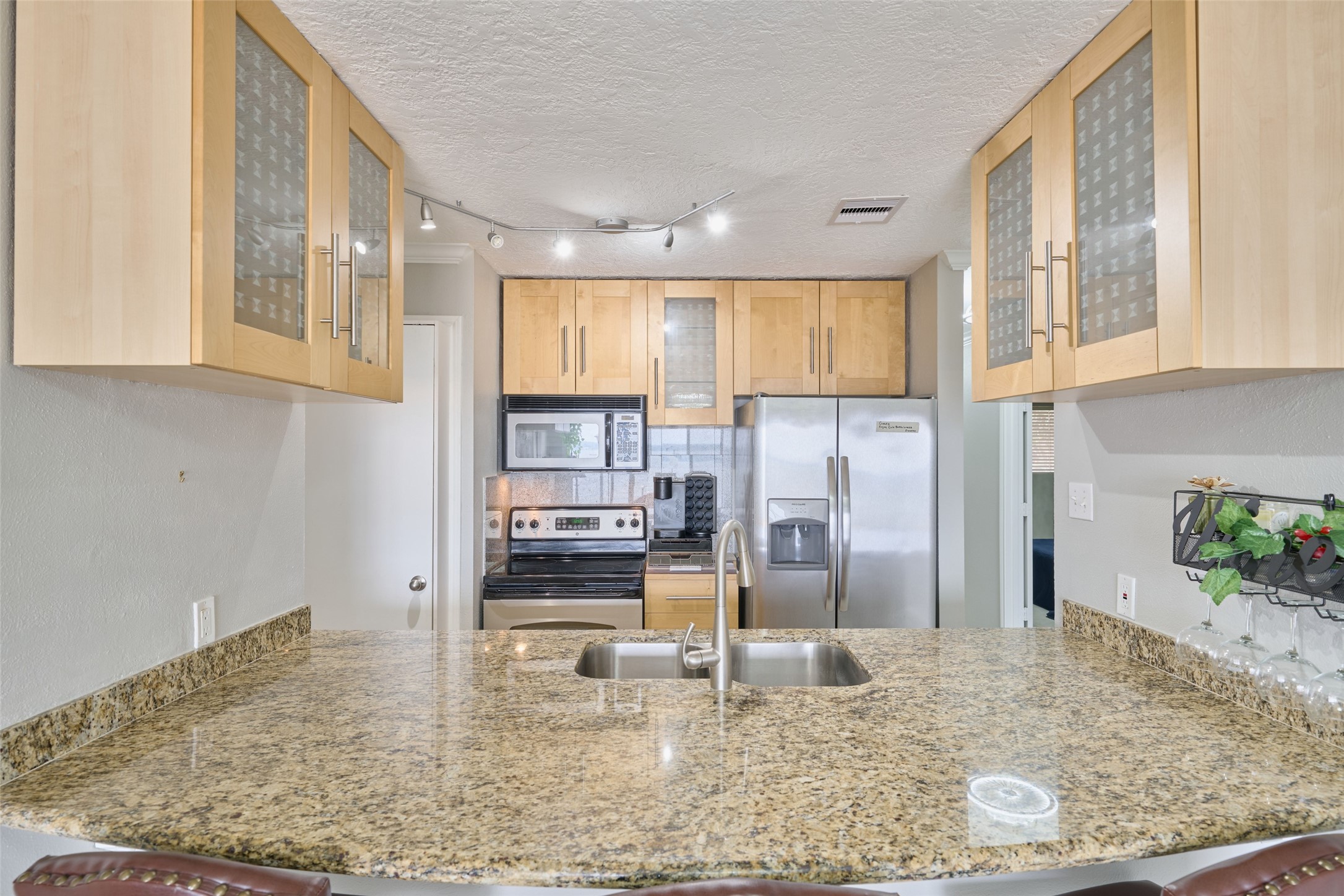 801 River Road, Unit 105D Montgomery, TX 77356 - Photo 6 of 32 Close up of breakfast bar and kitchen. The kitchen boasts granite counters, stainless steel appliances, new kitchen faucet. All appliances will remain including washer,dryer & refrigerator. Just bring your clothes & toothbrush!