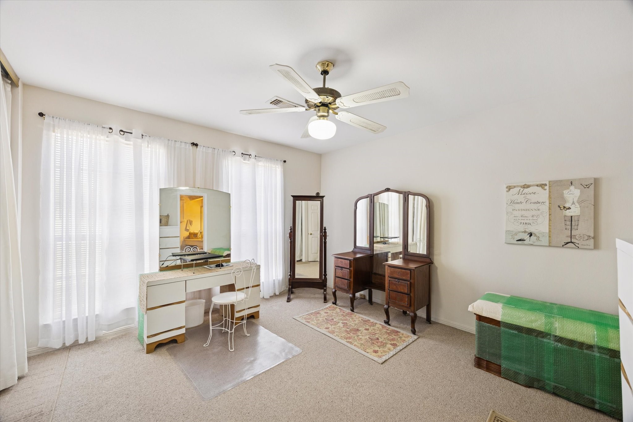 926 Rutland Street Houston, TX 77008 - Photo 13 of 28 Floor-to-ceiling windows anchor this spacious secondary bedroom, offering a bright and open feel. The room is equipped with a ceiling fan and durable carpeting.