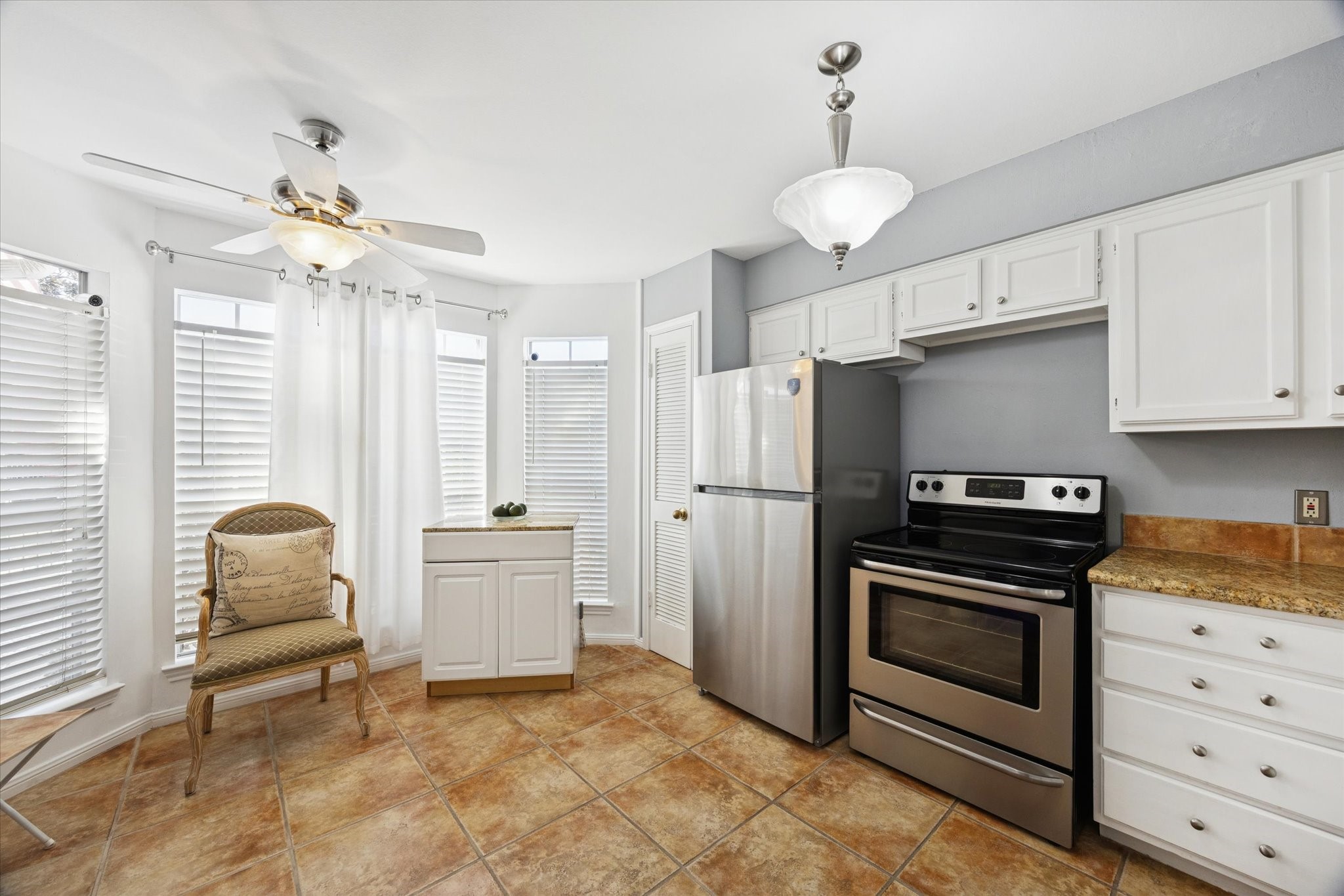 926 Rutland Street Houston, TX 77008 - Photo 4 of 28 Natural light fills this charming kitchen through abundant windows, highlighting the timeless granite counters and tile floors. A practical culinary hub, the space features extensive cabinetry and a pantry to meet all your storage needs.