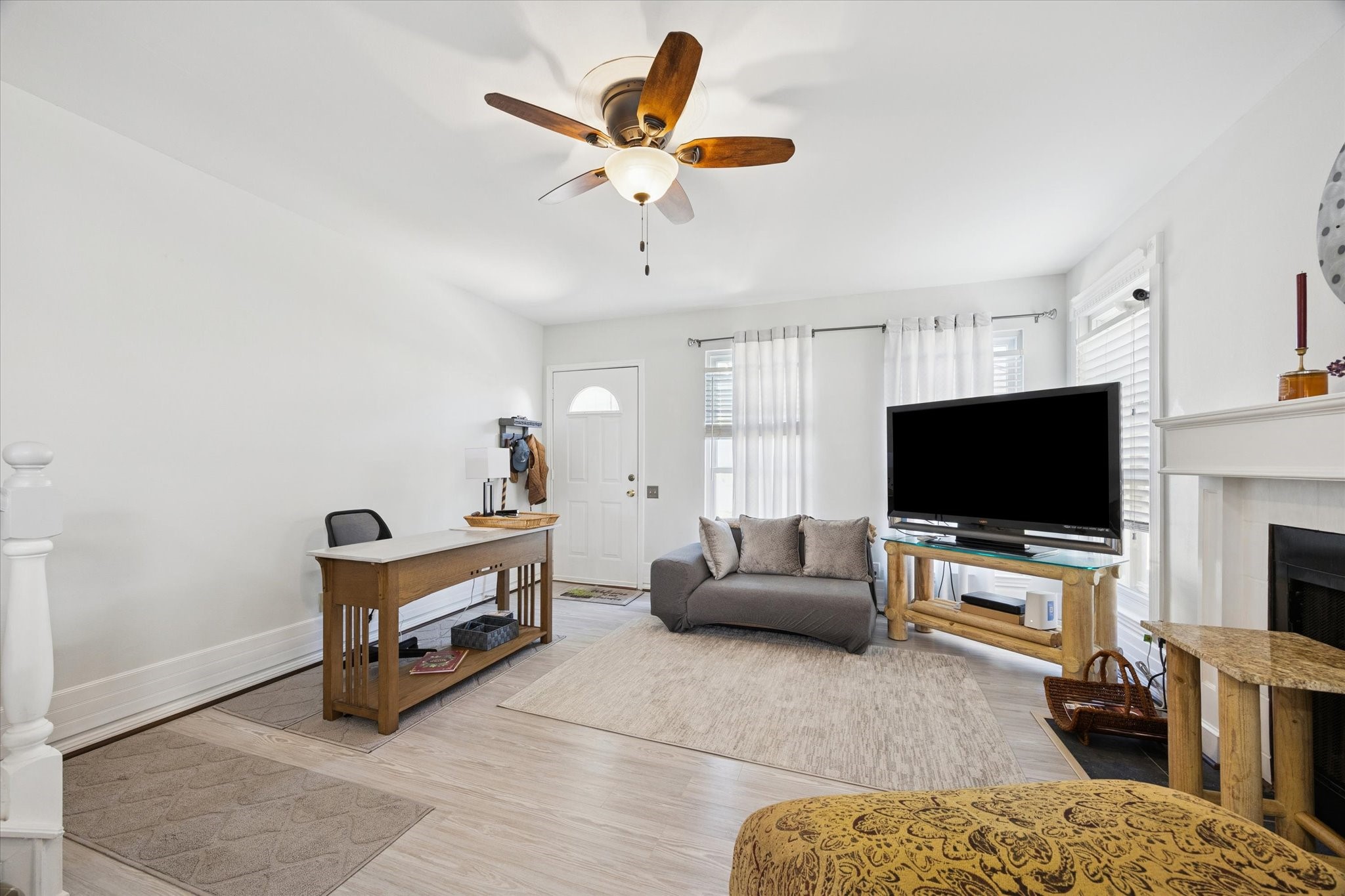 926 Rutland Street Houston, TX 77008 - Photo 8 of 28 Inviting living room features laminate wood flooring, a traditional wood-burning fireplace, and large windows for plenty of natural light.