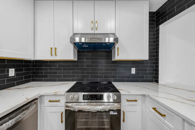 a stove top oven sitting inside of a kitchen