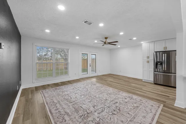 a view of empty room with wooden floor and window