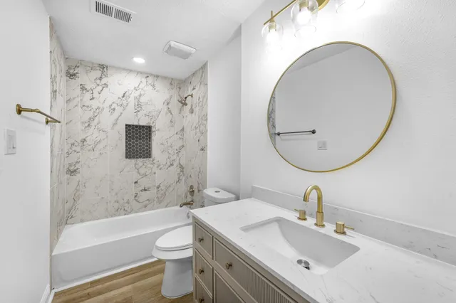 a bathroom with a sink a toilet and shower