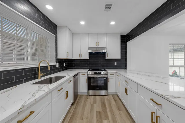 a kitchen with a sink stove and cabinets