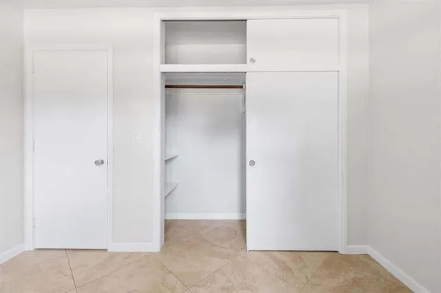 an empty room with windows and ceiling fan