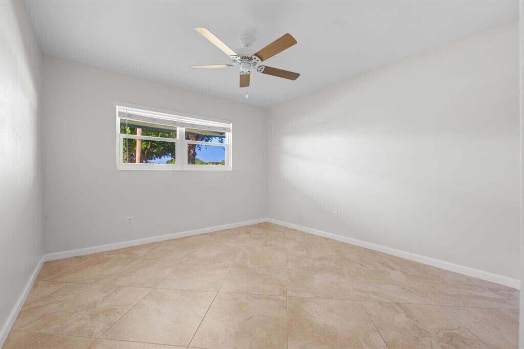 3801 Northeast 22nd Terrace, Unit 2 Lighthouse Point, FL 33064 - Photo 12 of 19 an empty room with windows and ceiling fan