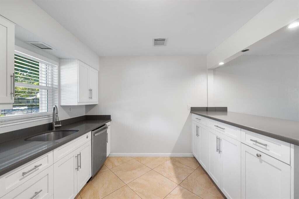3801 Northeast 22nd Terrace, Unit 2 Lighthouse Point, FL 33064 - Photo 3 of 19 a kitchen with granite countertop white cabinets and window