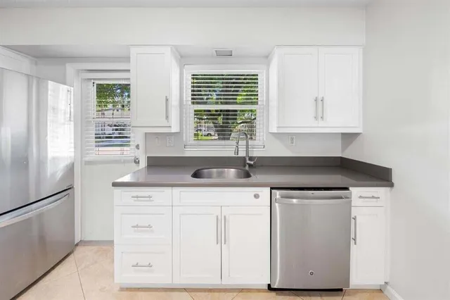 a kitchen with stainless steel appliances granite countertop a sink and a window
