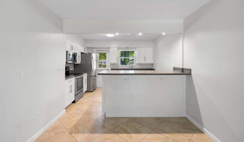 3801 Northeast 22nd Terrace, Unit 2 Lighthouse Point, FL 33064 - Photo 6 of 19 a kitchen with stainless steel appliances granite countertop a sink and cabinets