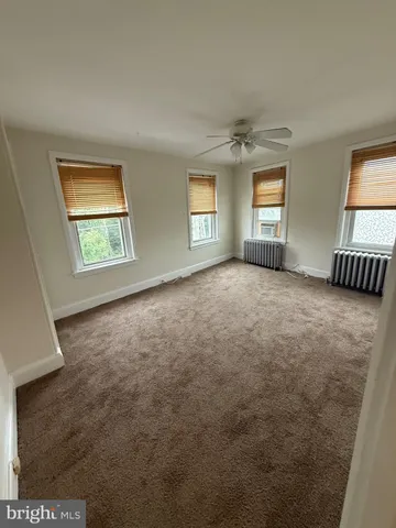 an empty room with windows and cabinet