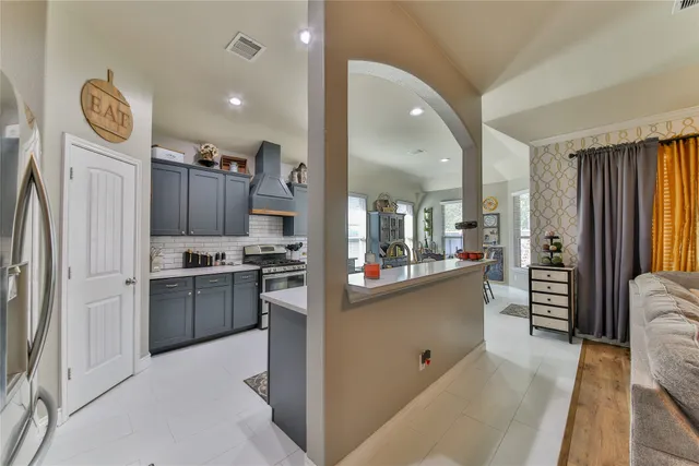 a kitchen with stainless steel appliances kitchen island granite countertop a refrigerator and a stove top oven