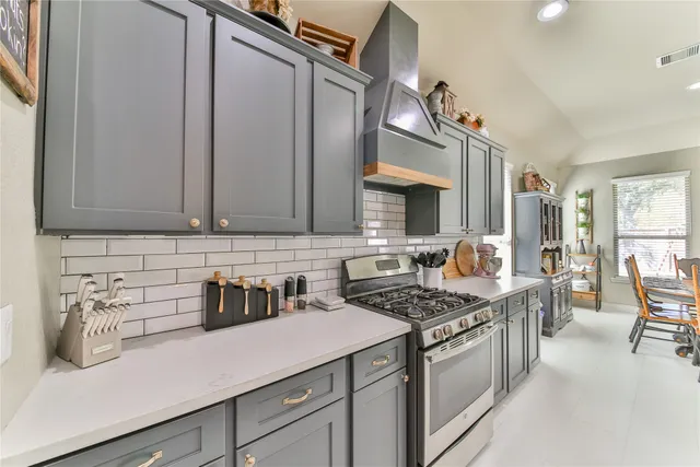 a kitchen with stainless steel appliances a sink stove and cabinets