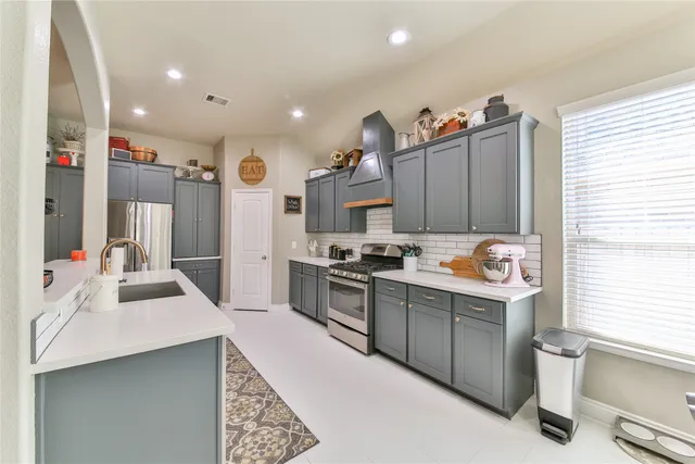a kitchen with stainless steel appliances kitchen island granite countertop a sink stove and refrigerator