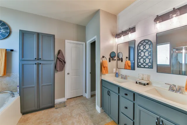 a spacious bathroom with a double vanity sink mirror and shower