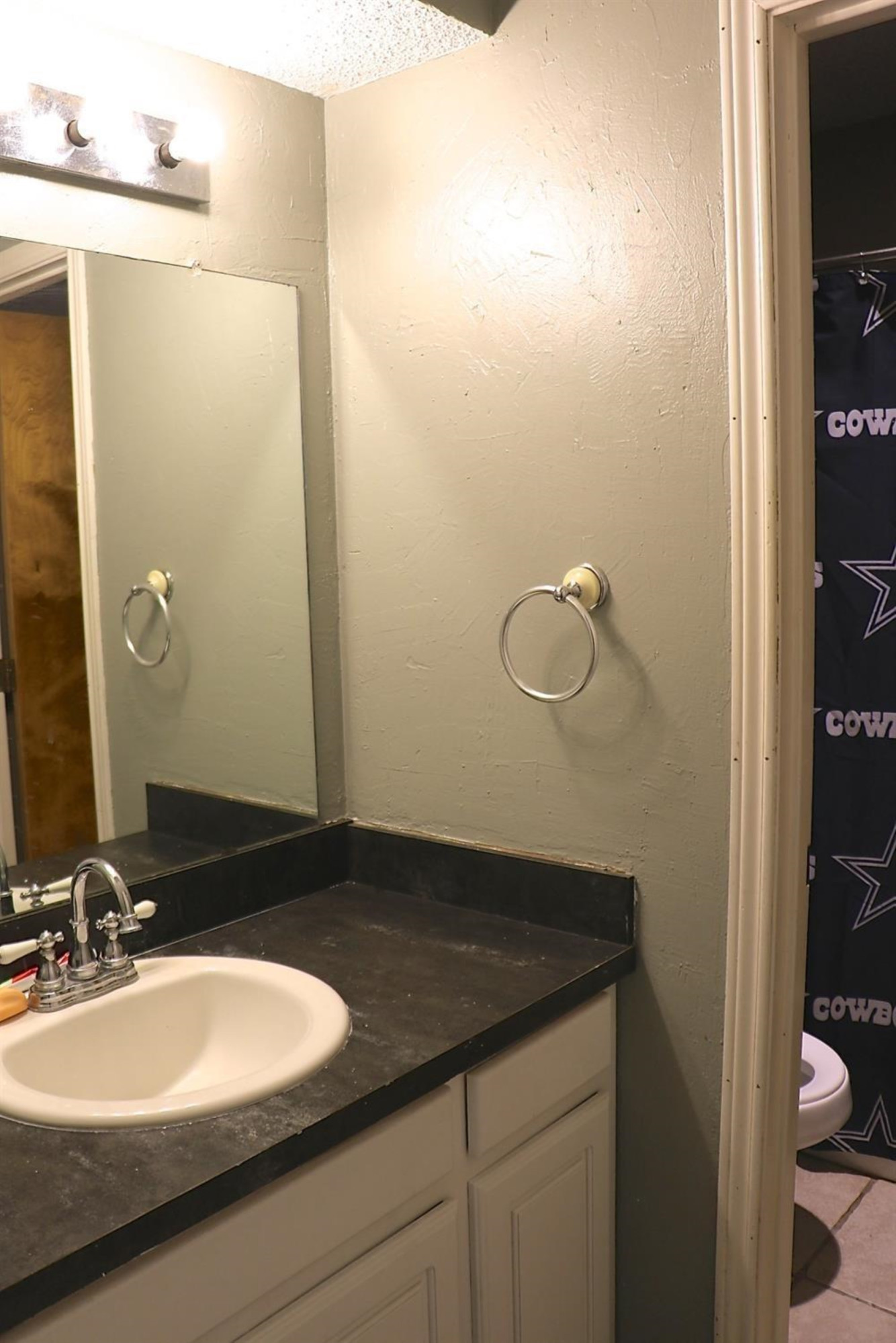 7004 Elkhart Avenue Lubbock, TX 79424 - Photo 12 of 16 a bathroom with a granite countertop sink and a mirror