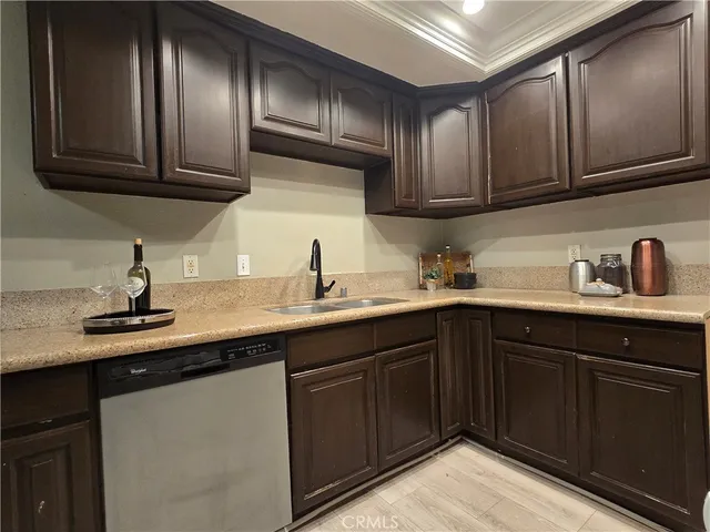 a kitchen with stainless steel appliances granite countertop wooden cabinets and a sink