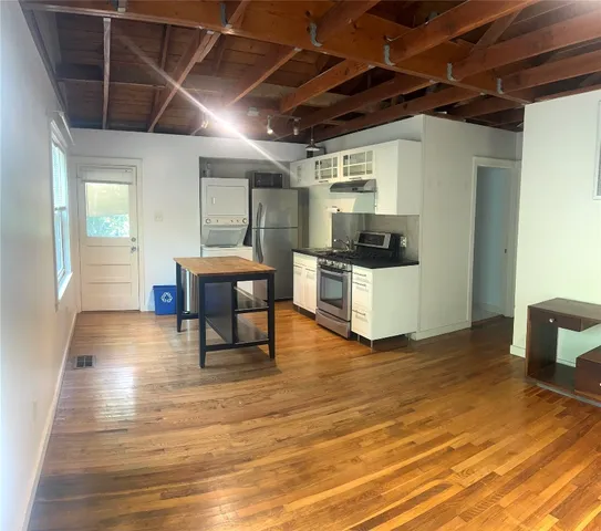 a view of a room with wooden floor and furniture