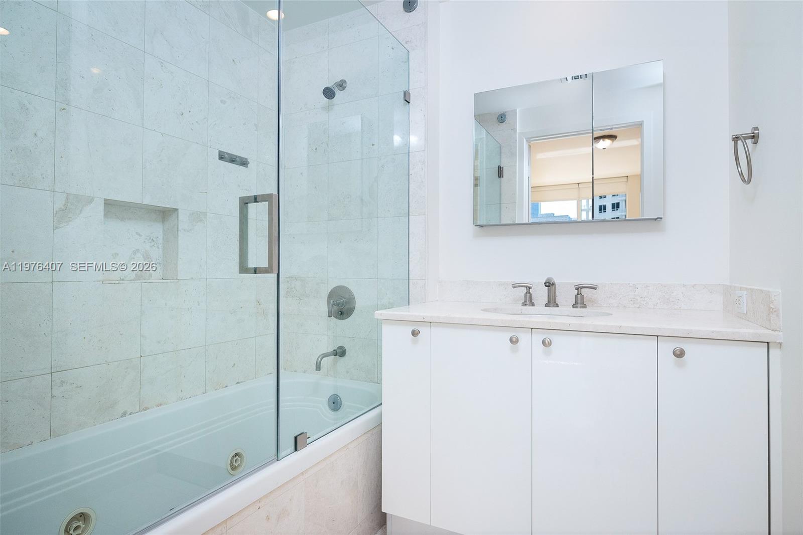 901 Brickell Key Boulevard, Unit 901 Miami, FL 33131 - Photo 16 of 35 a bathroom with a sink a mirror a shower and a bathtub