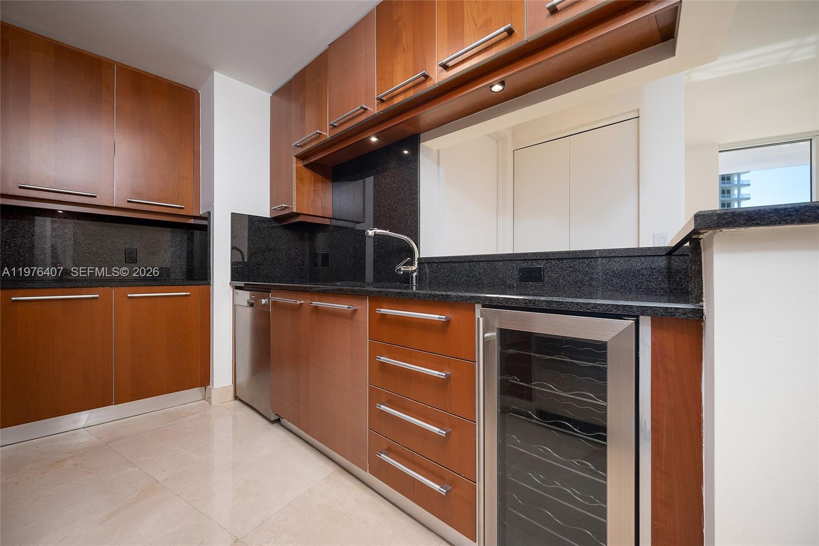 901 Brickell Key Boulevard, Unit 901 Miami, FL 33131 - Photo 21 of 35 a kitchen with granite countertop a stove and a microwave