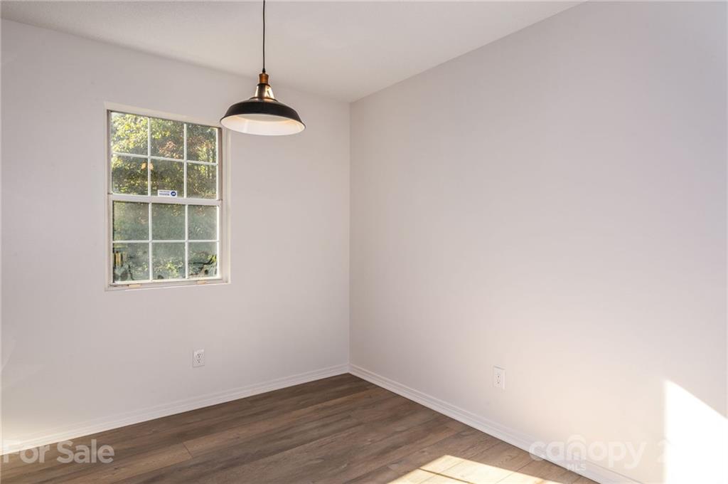 1401 Locust Grove Road Hendersonville, NC 28792 - Photo 9 of 20 a view of an empty room with wooden floor and a window