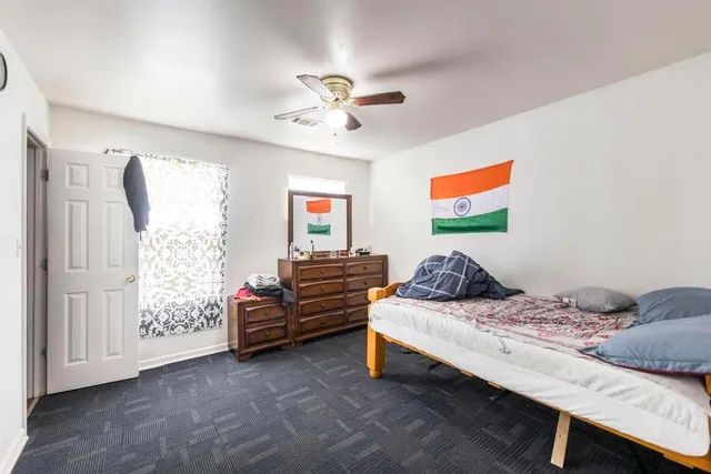 a bedroom with a bed and dresser with mirror