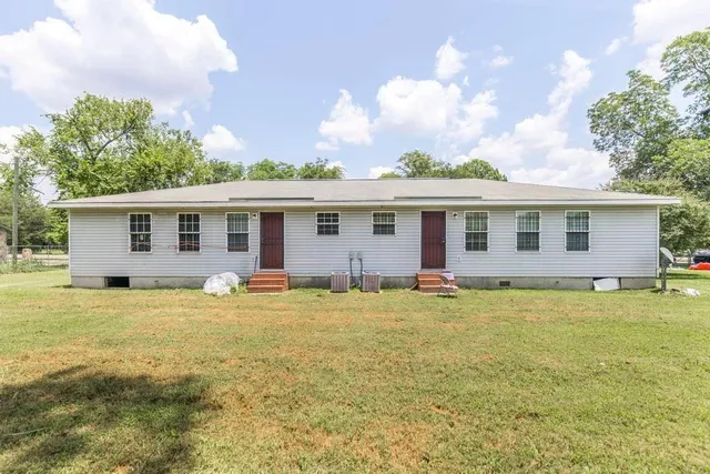 a front view of house with yard and trees around