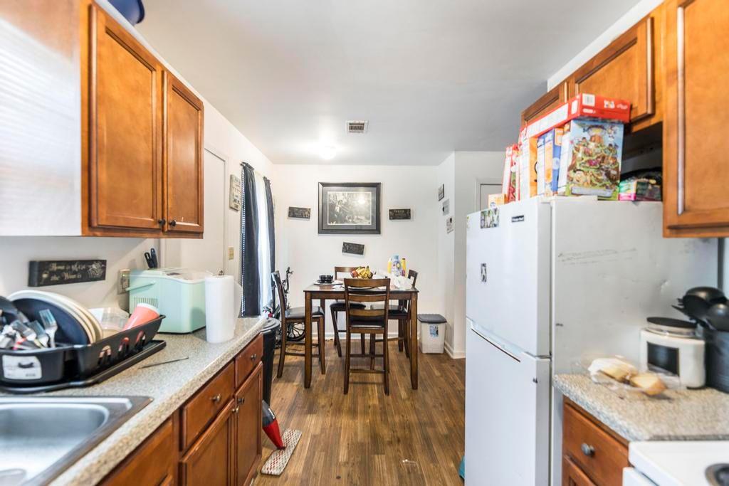 210 Perry Railroad Street Fort Valley, GA 31030 - Photo 30 of 45 a kitchen with stainless steel appliances granite countertop a refrigerator a stove a sink a dining table and chairs with wooden floor
