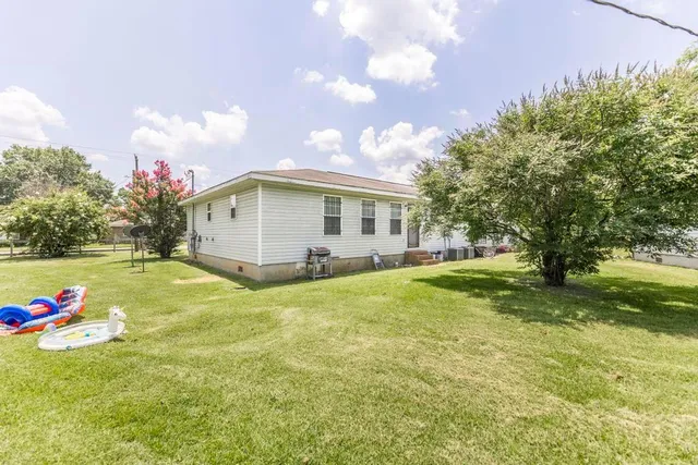 a view of a house with a patio and a yard
