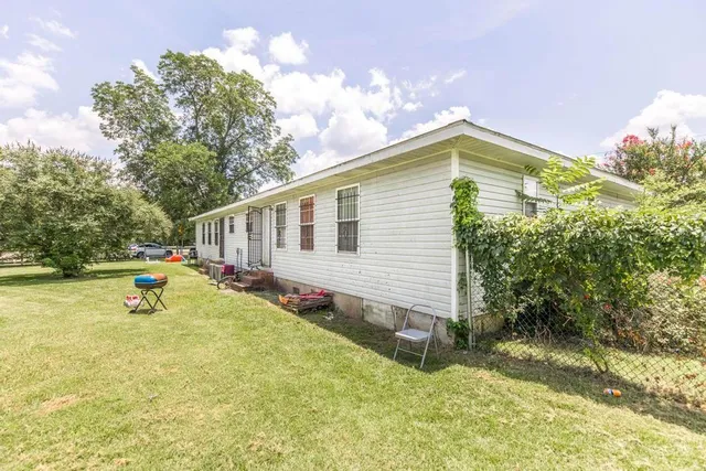 a view of a house with backyard and sitting area