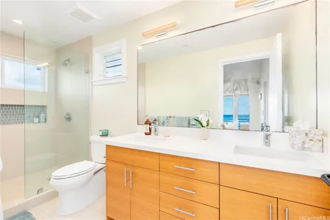 a bathroom with a granite countertop sink mirror vanity and toilet