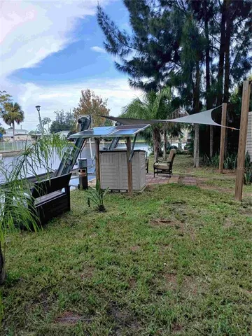 a view of a backyard with table and chairs under an umbrella