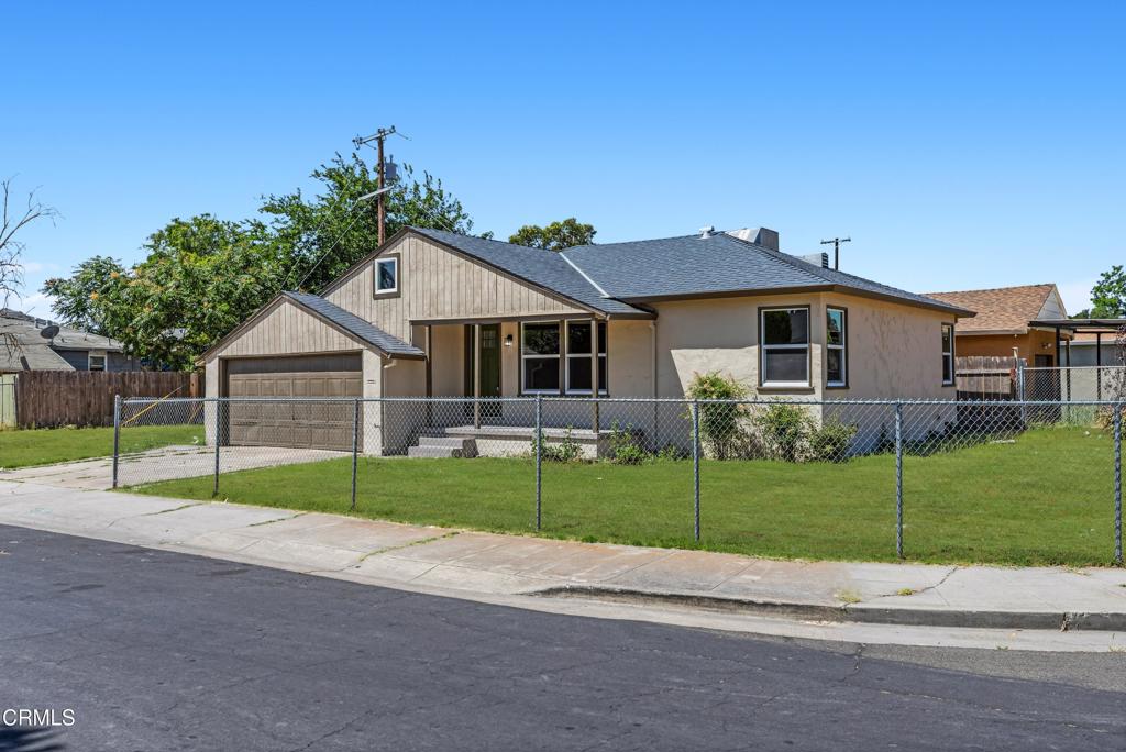 a view of a house with a big yard plants and big trees