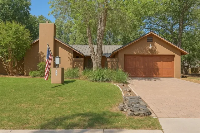 a view of a house with backyard and trees