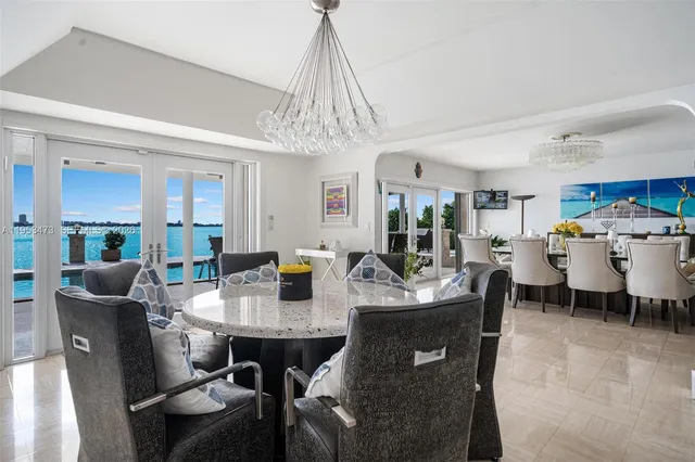 a dining room with furniture a kitchen view and a chandelier